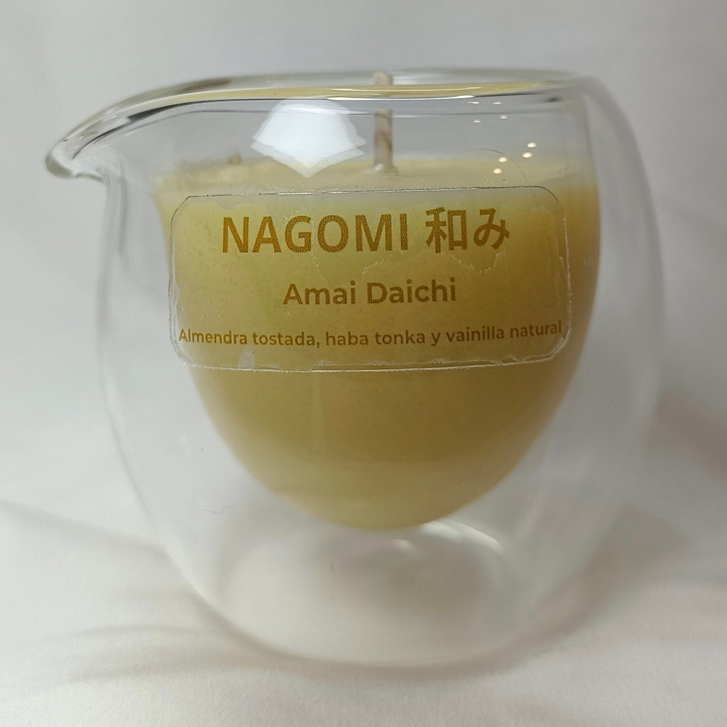 Vela de masaje 'Amai Daichi' con etiqueta Nagomi y aromas a almendra tostada, haba tonka y vainilla natural.