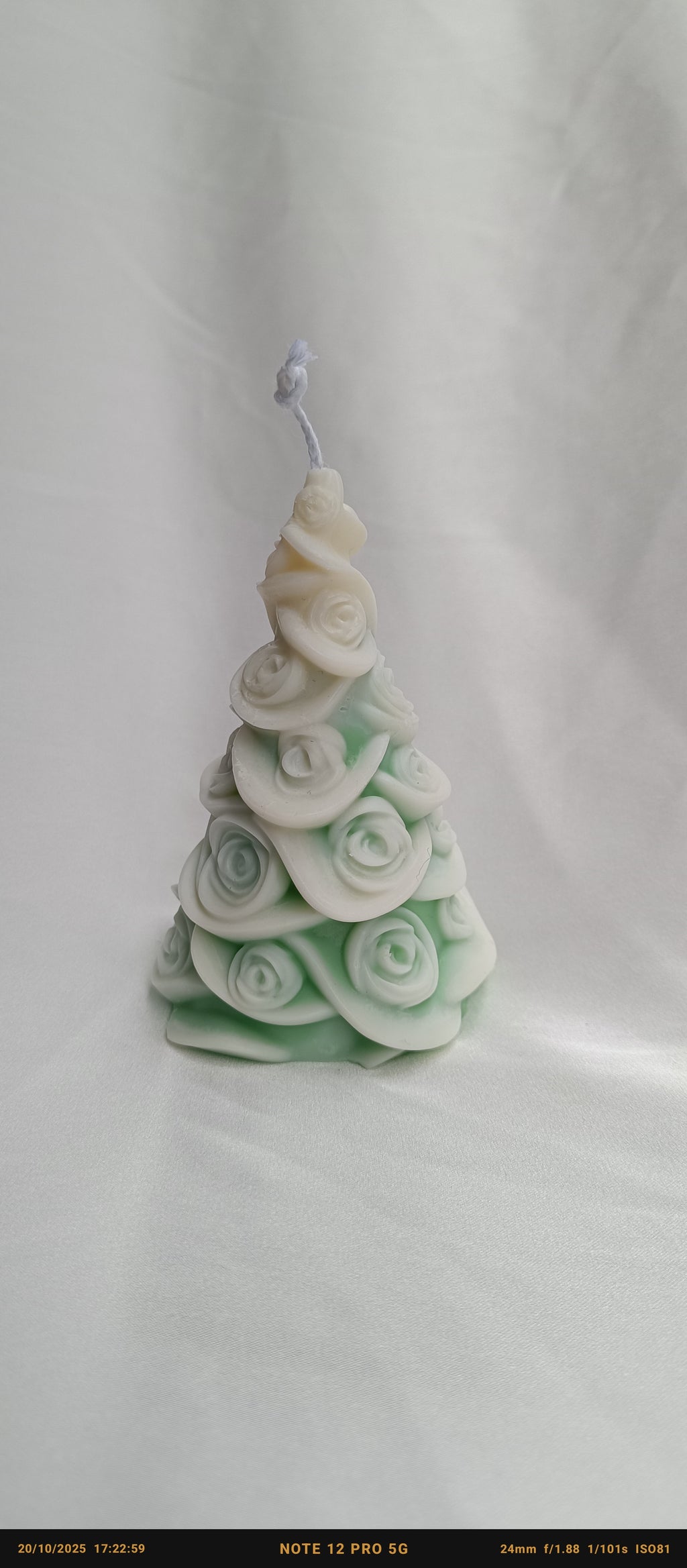 Detalle de vela Árbol de Navidad artesanal, cubierta de rosas blancas y verdes, ideal como decoración romántica.