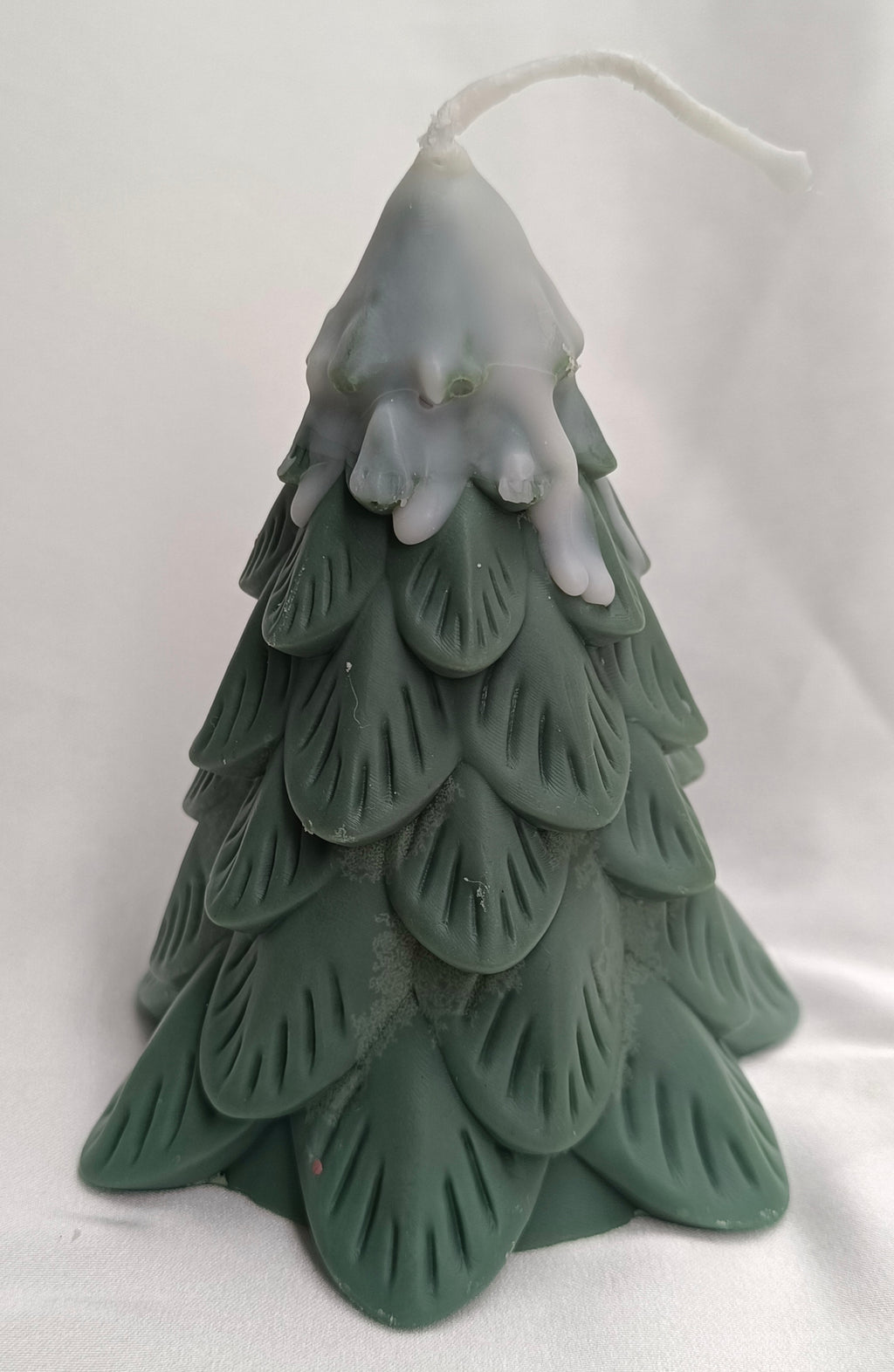 Vela de Navidad en forma de pino nevado, con textura de ramas y color verde oscuro, para un ambiente invernal.