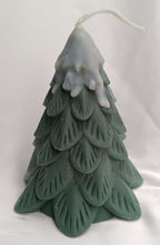 Vela de Navidad en forma de pino nevado, con textura de ramas y color verde oscuro, para un ambiente invernal.