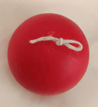 Vela artesanal Bola de Navidad roja con mecha anudada para colgar, hecha a mano con cera natural.