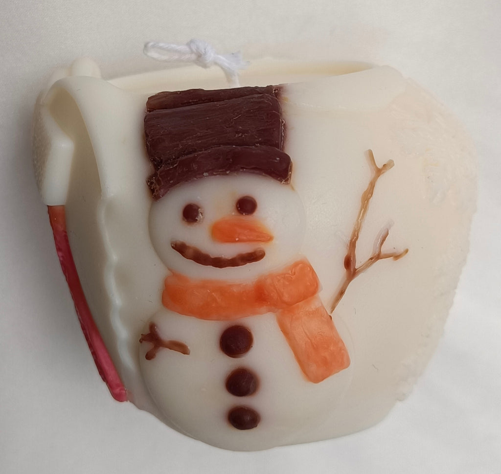 Vela de Navidad en forma de bola con elegantes copos de nieve tallados, hecha a mano en Barcelona con cera natural.