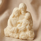 Vela decorativa o figura de cera en color blanco roto con forma de la Sagrada Familia y base de rosas. Presentada sobre fondo textil neutro