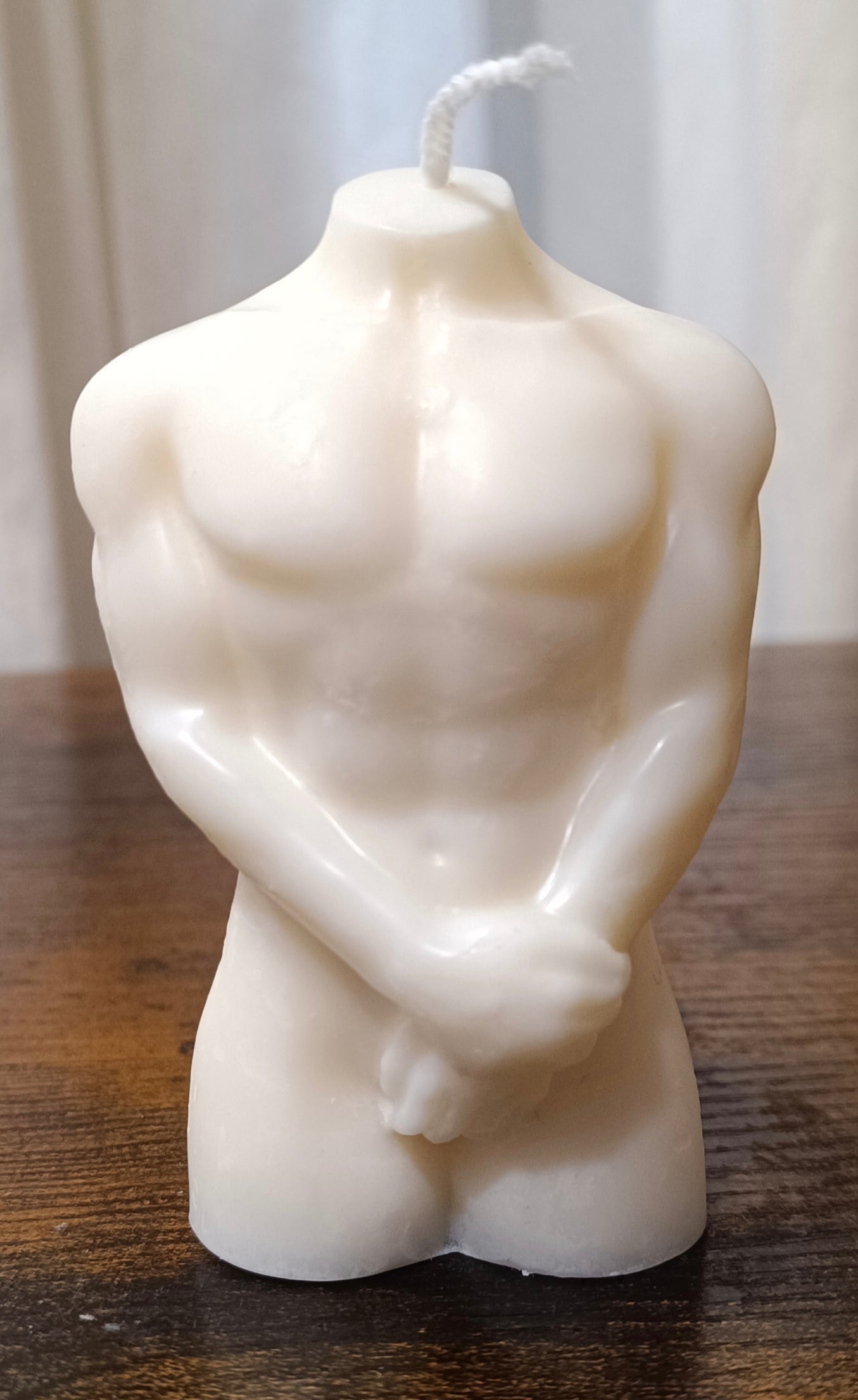 Vela artesanal en forma de torso masculino desnudo con manos cubriendo zona íntima, para despedidas de soltero.