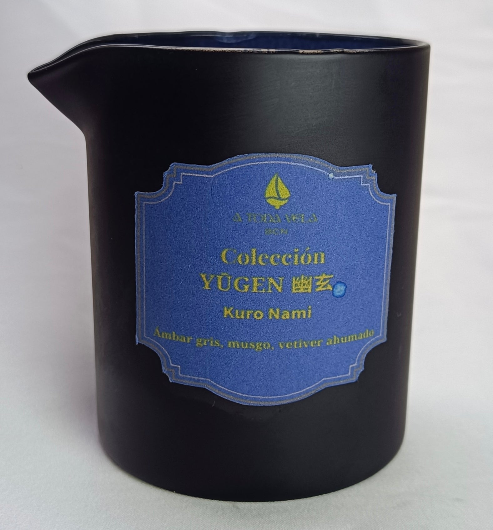 Vela de masaje 'Kuro Nami' en su jarra de cerámica negra, mostrando la cera de soja natural lista para un masaje de introspección.