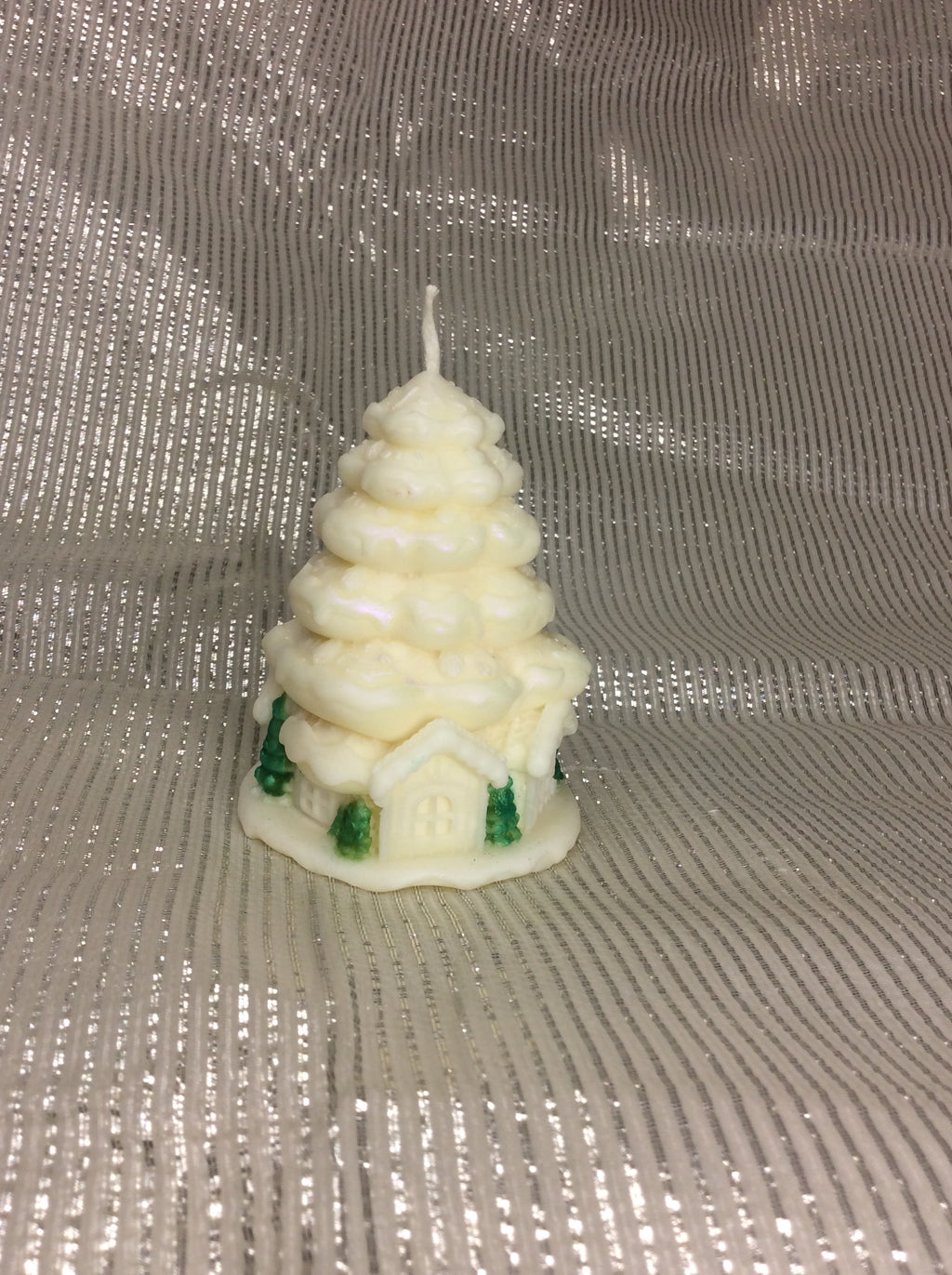 Vela de Navidad con forma de árbol nevado y casa en la base, con acabado nacarado.