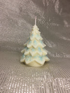Vela de Navidad con forma de árbol y copos de nieve azules pintados a mano.