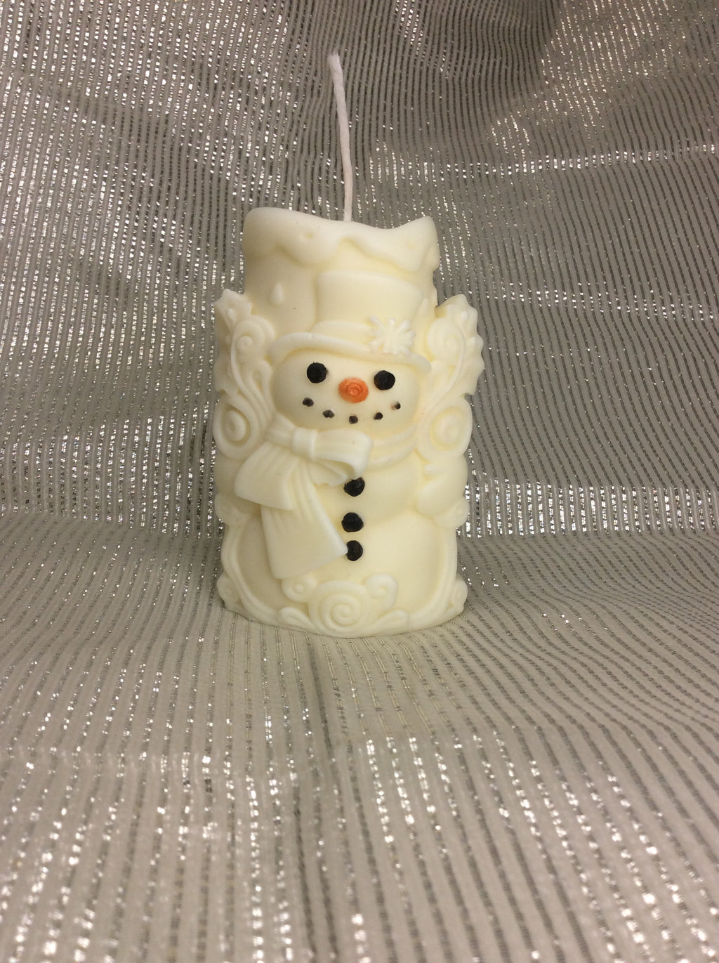 Vela de Navidad artesanal con forma de muñeco de nieve y detalles pintados a mano.