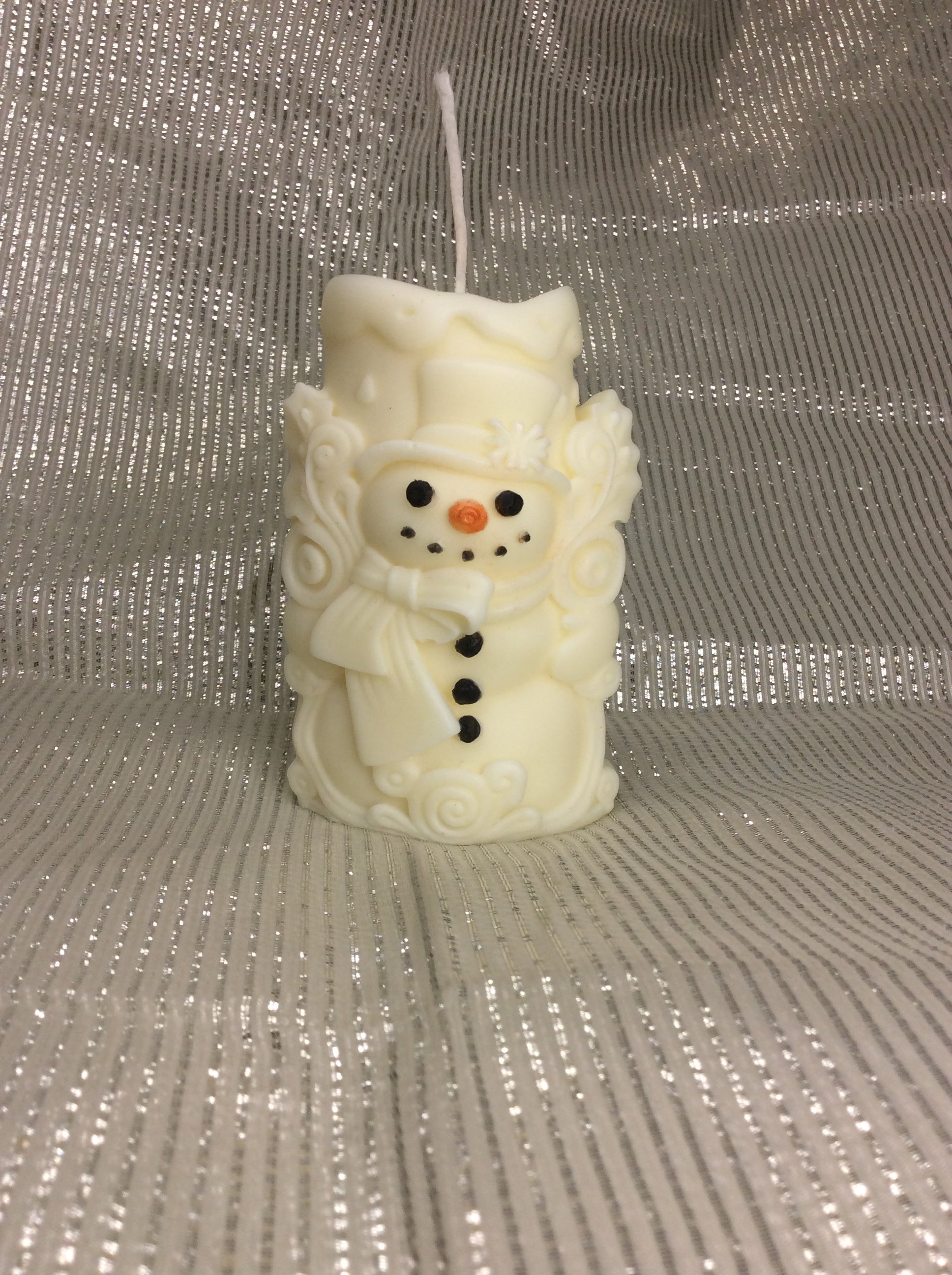 Vela de Navidad artesanal con forma de muñeco de nieve y detalles pintados a mano.