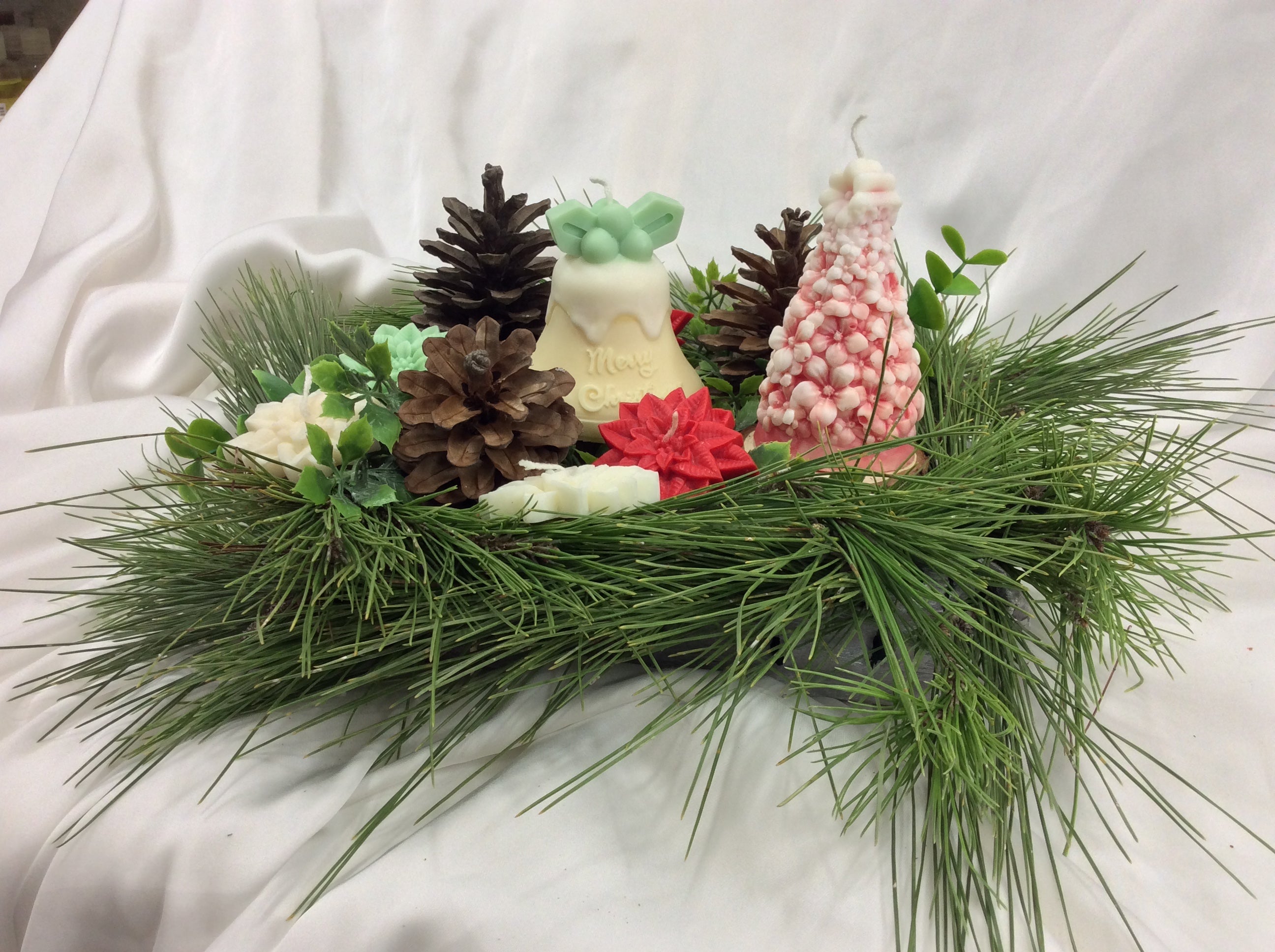 Velas navideñas con forma de campana y árbol con detalles en rojo.