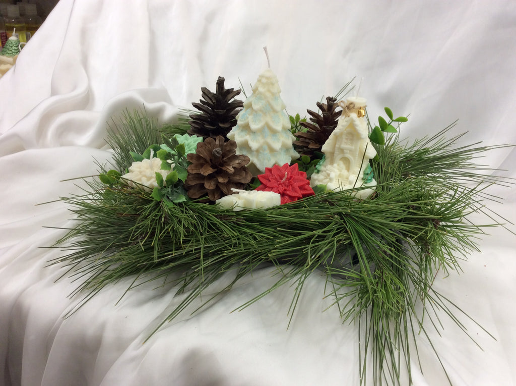 Velas decorativas de Papá Noel y árbol de Navidad sobre una base de pino.