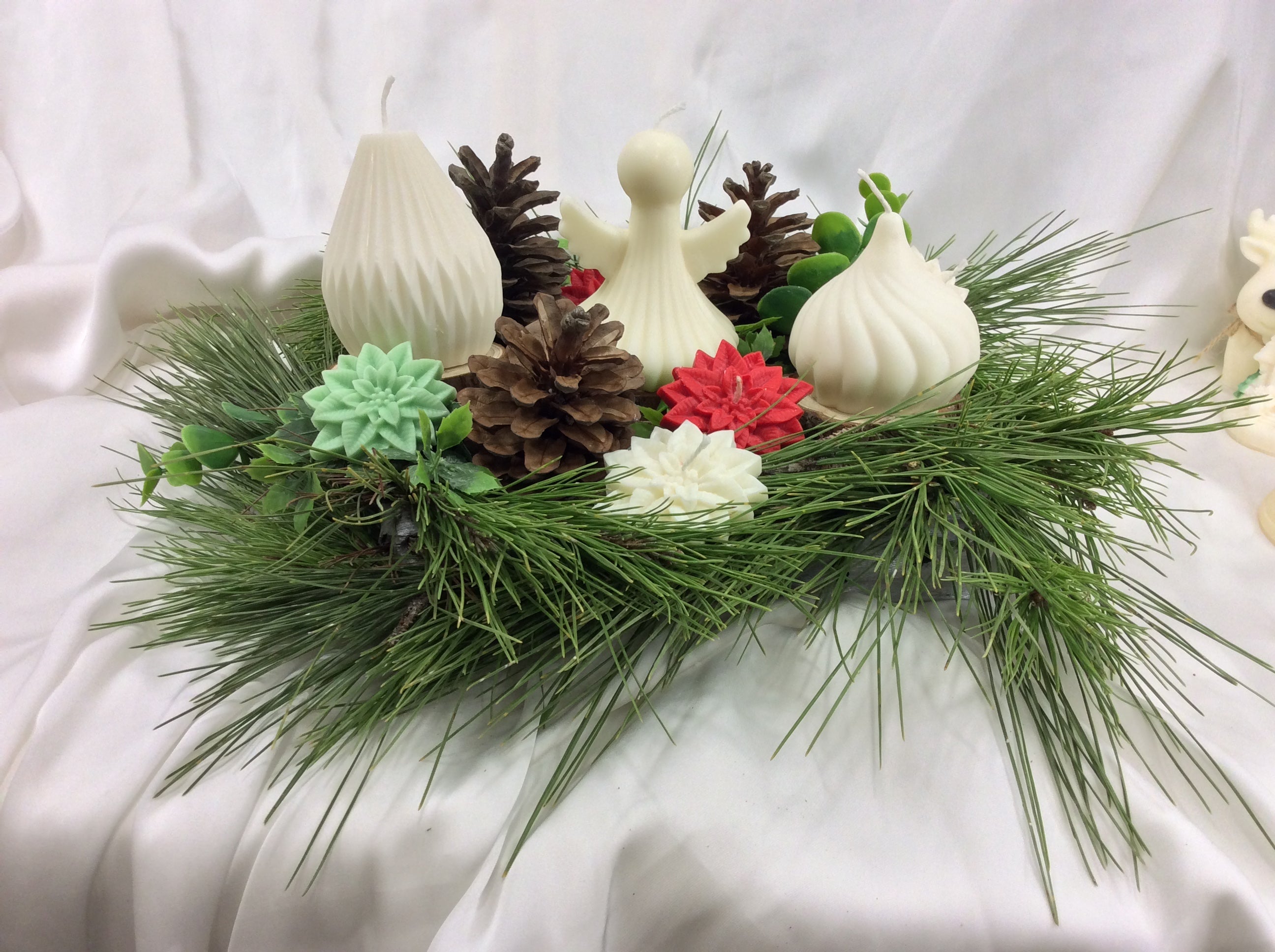  Arreglo de velas con figura de ángel y dos velas geométricas sobre pino.