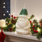 Vela de Papá Noel decorando un centro de mesa navideño junto a piñas y acebo.