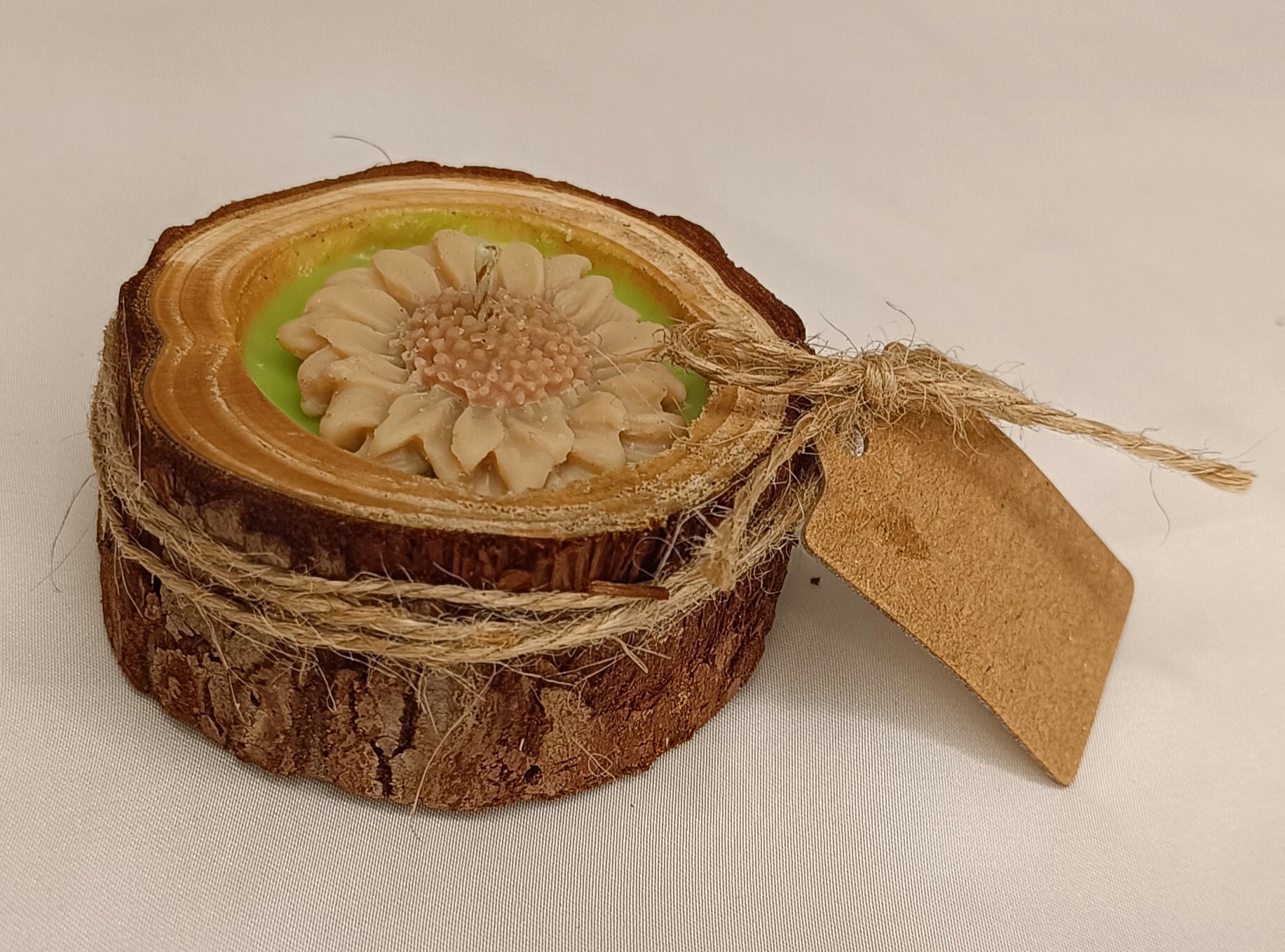 Vela Recordatorio rústica en base de tronco de madera natural. Homenaje ecológico con flor de cera y etiqueta kraft personalizable.