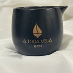 Recipiente de lujo negro para vela de masaje Kohaku Hada. Cerámica con logo dorado A Toda Vela BCN. Ideal para Spas y uso profesional.