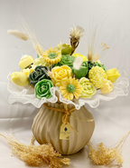 Centro de Mesa Sostenible Malta. Arreglo floral de lujo en tonos vibrantes (amarillo y verde), presentado en contenedor de tela. Decoración 100% ecológica.