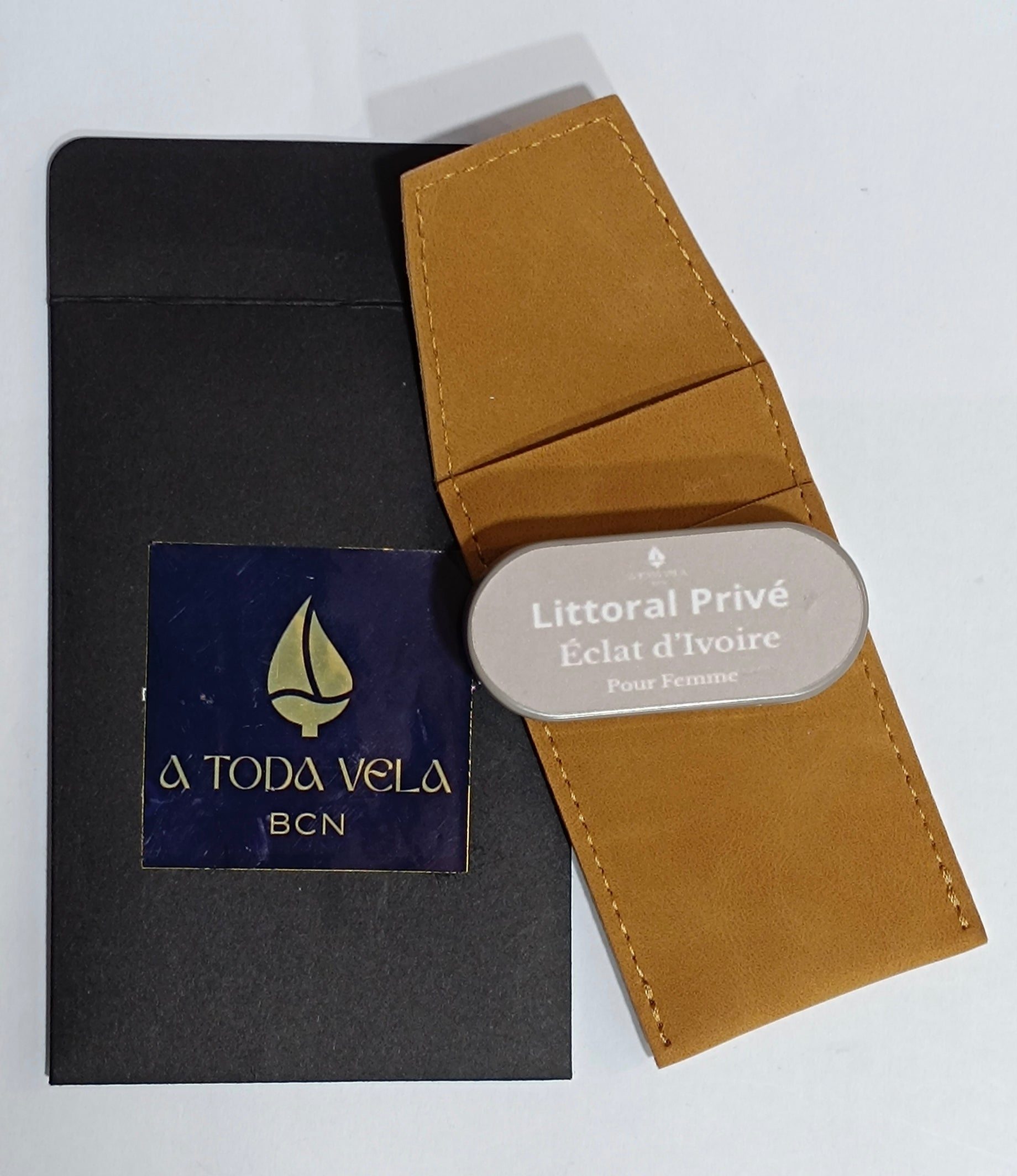 Packaging del perfume sólido femenino 'Éclat d'Ivoire' de Litoral Privé: estuche metálico nude, funda de antelina y sobre negro, hecho en Barcelona.