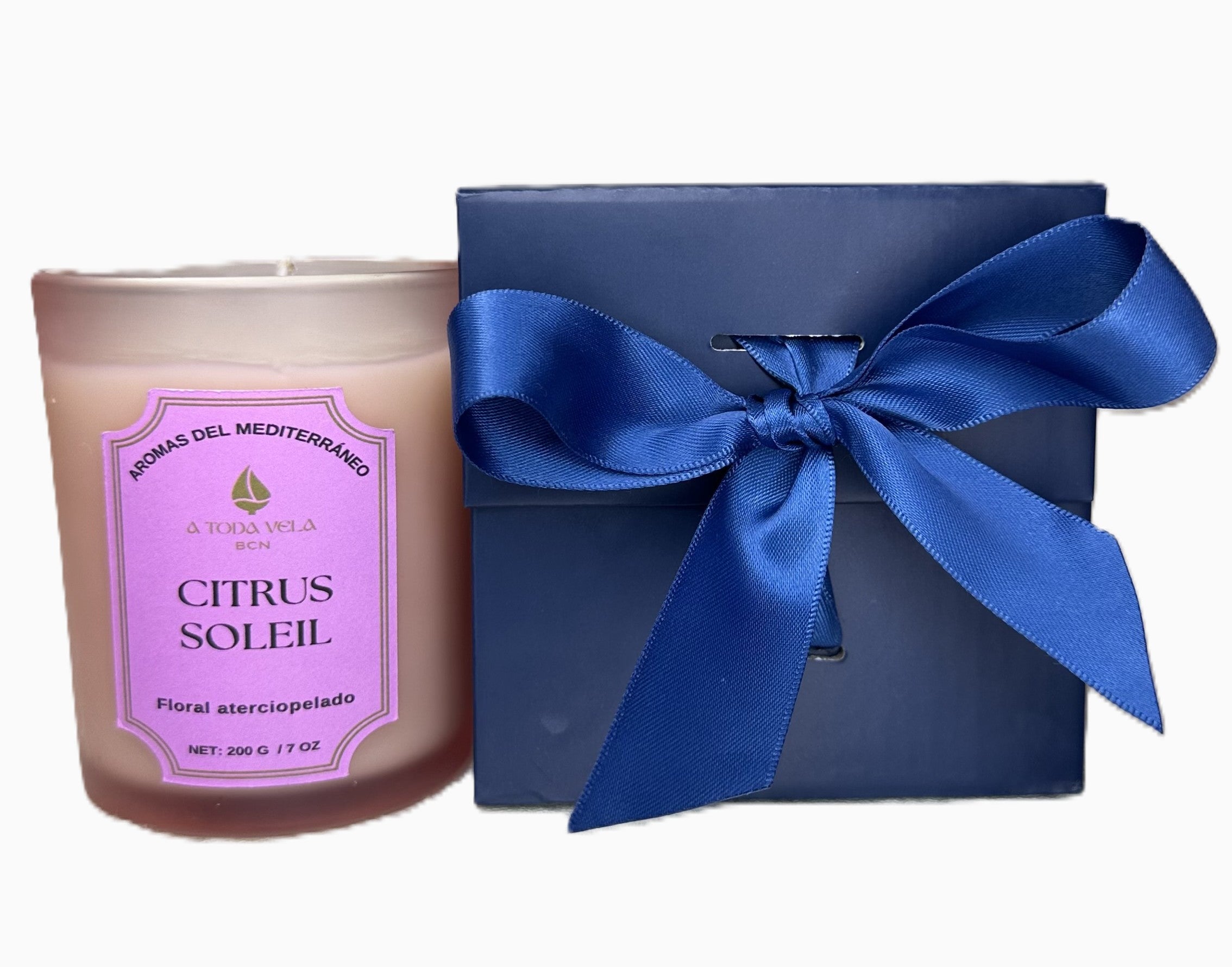 Set de regalo de la vela Citrus Soleil de lujo. La vela de 200g de cera de soja ecológica está junto a su caja de presentación en color azul marino atada con un lazo de raso azul. Ideal como regalo corporativo o detalle para eventos, el pack refleja la calidad premium de la marca A Toda Vela BCN y la fragancia Cítrica y limpia inspirada en el Mediterráneo.