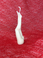 Vista lateral de la vela sensual de piernas sobre encaje rojo.