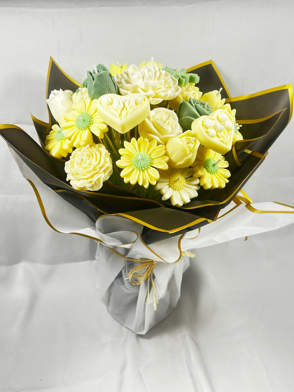Ramo de Velas Artesanales Barcelona. Regalo de lujo, con flores de cera vegetal en tonos amarillos, envuelto en packaging negro y dorado.