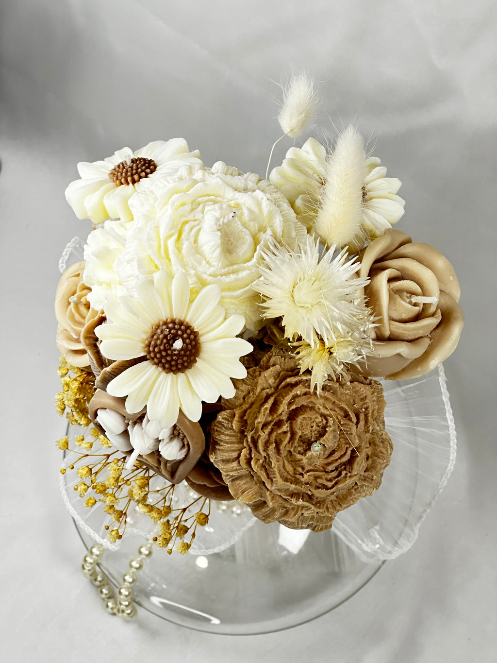 Detalle del bouquet de velas de cera vegetal. Rosas, margaritas y flores secas en tonos neutros y crema. Arreglo floral eterno para decoración de lujo.