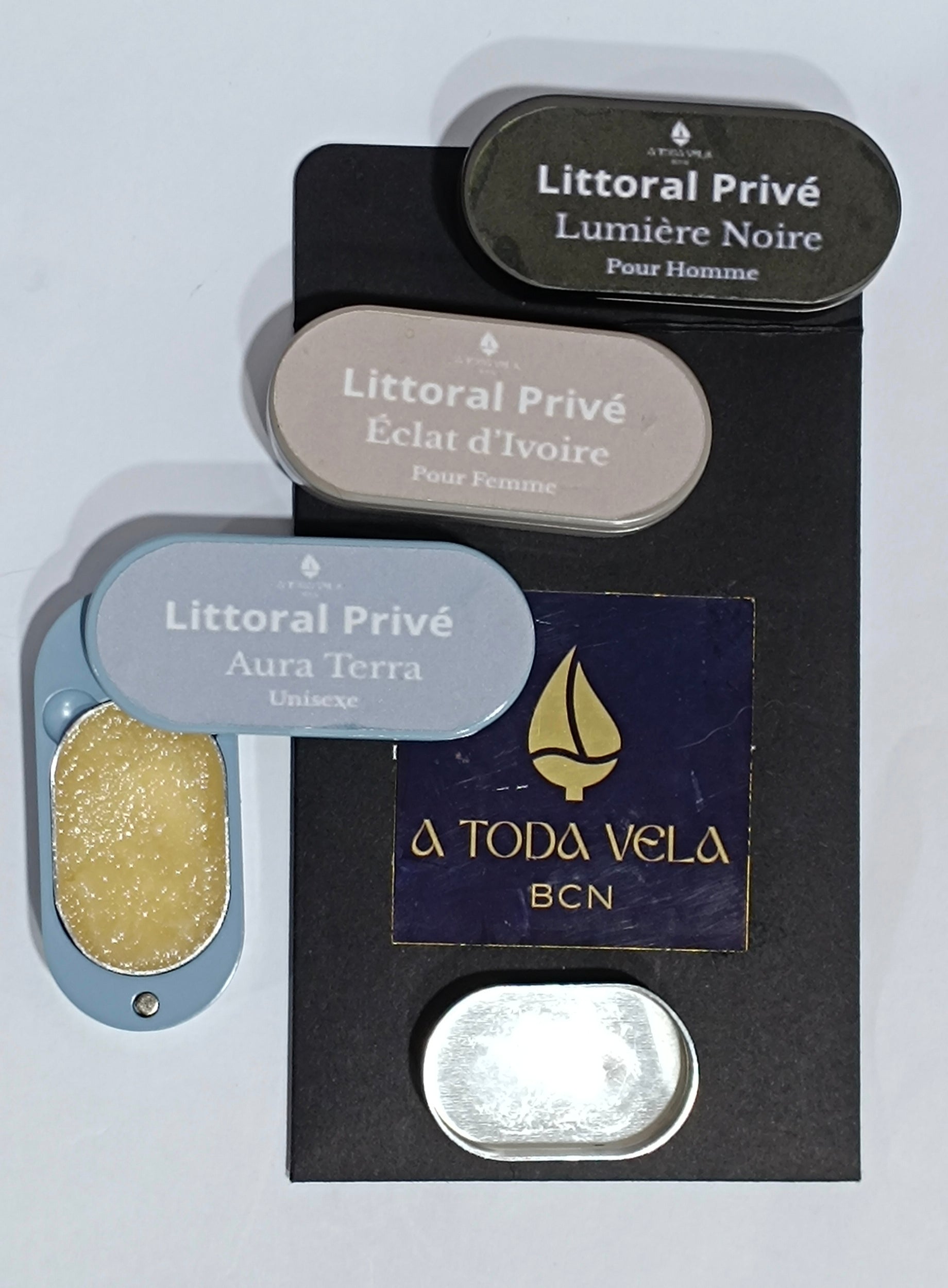 Recambio abierto del perfume sólido Aura Terra (unisex) con cera perfumada natural, junto a otros estuches de la colección Litoral Privé.