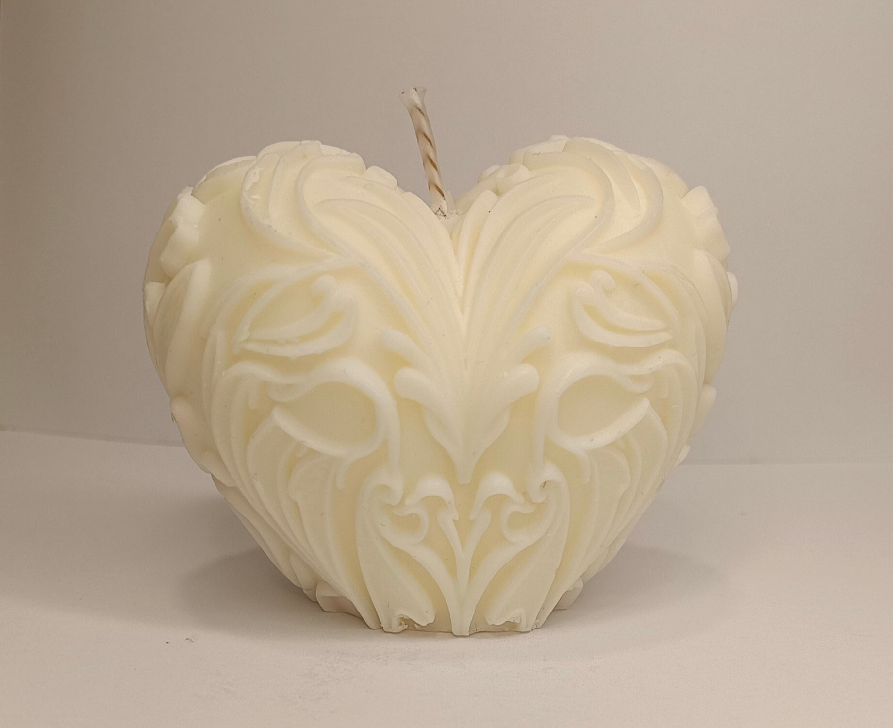 Detalle del relieve floral de la Vela Corazón de lujo. Cera ecológica color marfil, perfecta para decoración y souvenirs de eventos.