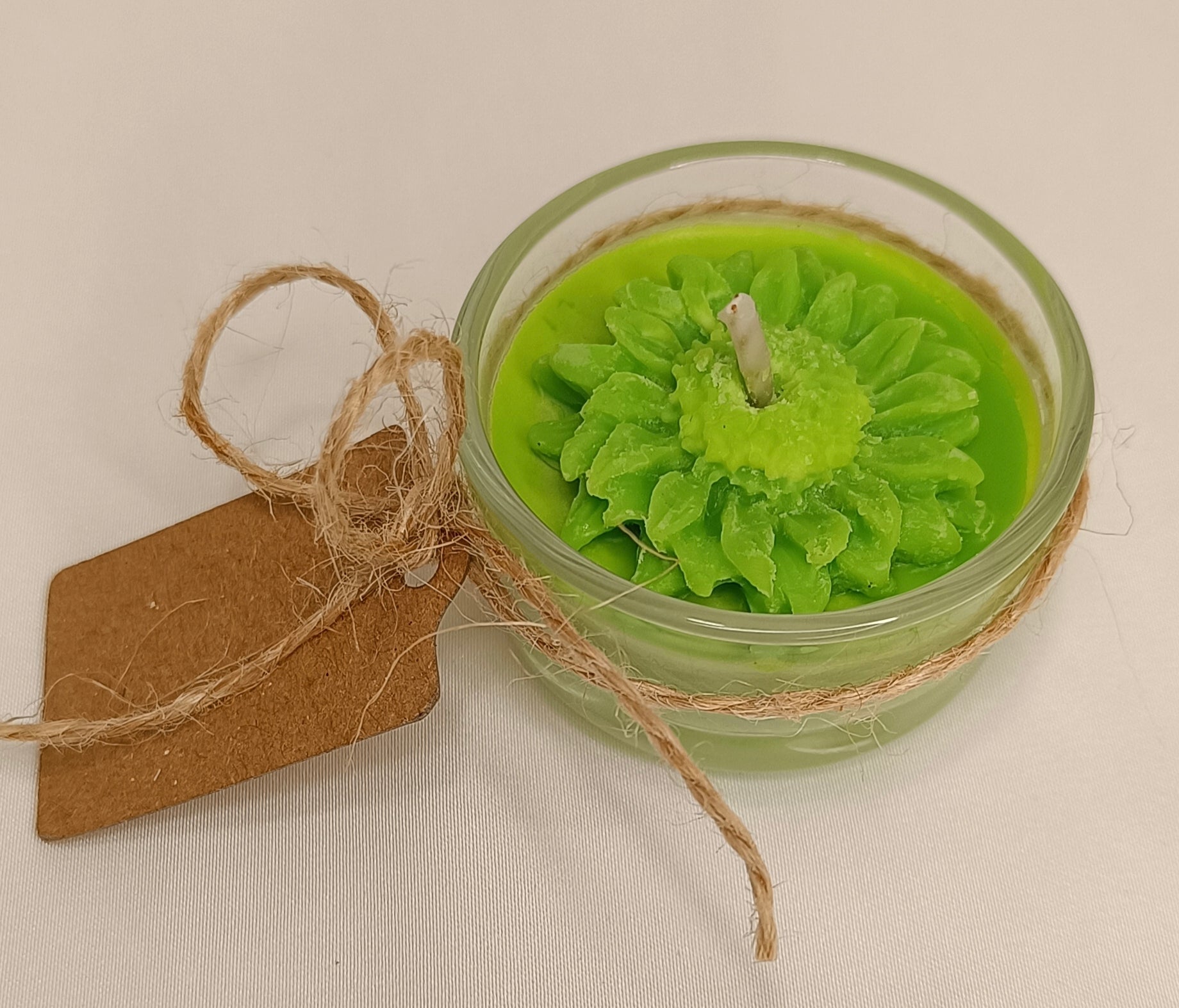 Detalle de la flor de cera en Vela Recordatorio. Diseño de lujo con cera vegetal color verde claro, ideal para ceremonias de memoria y respeto.