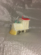 Vela de Navidad con forma de locomotora de tren, pintada a mano en rojo y dorado.