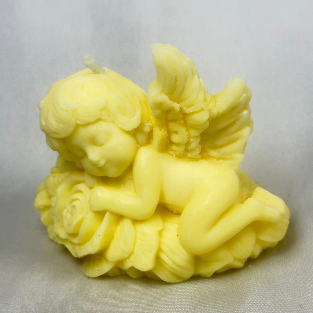 Vela de bautizo artesanal ecológica con figura de ángel durmiendo, símbolo de protección."