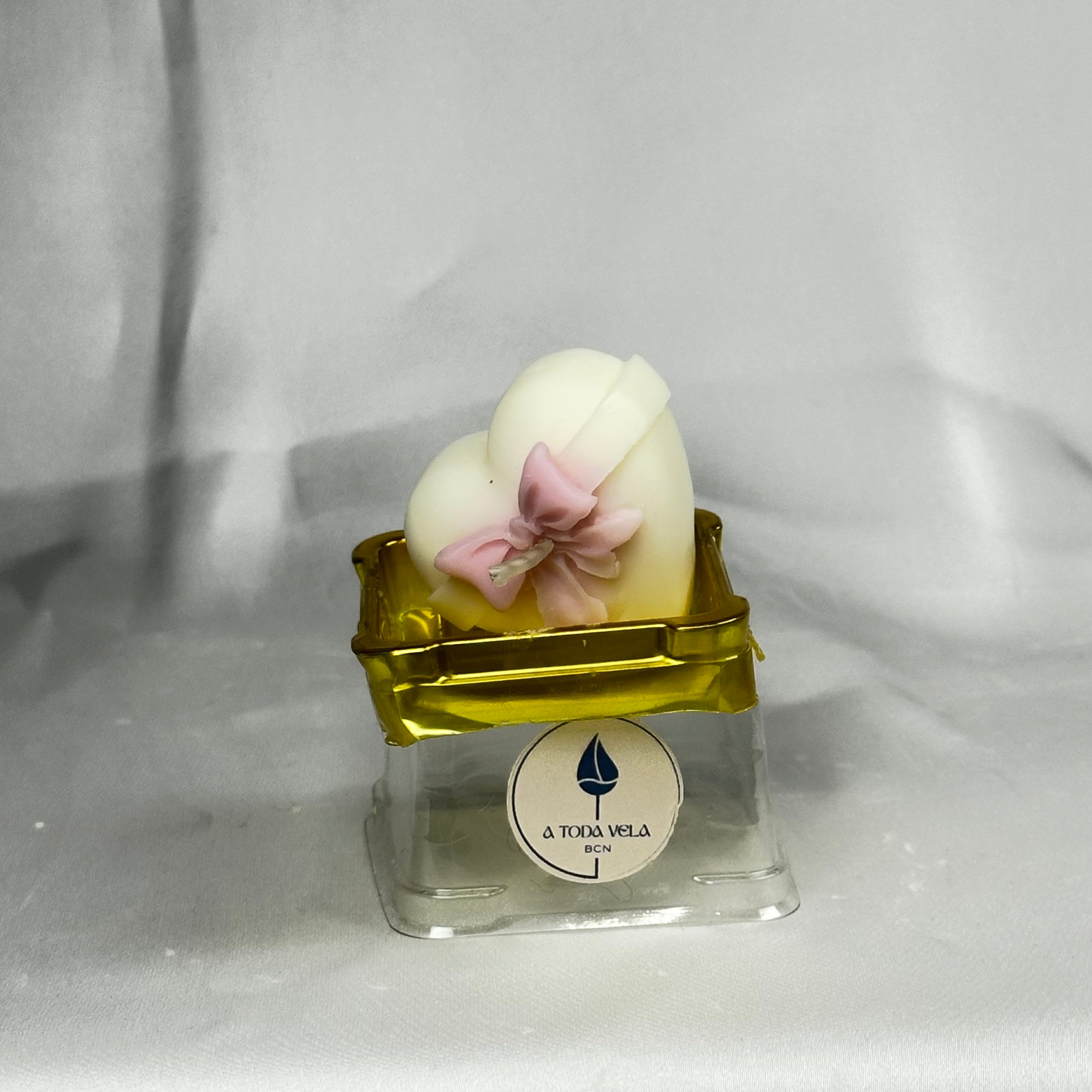 "Vela de regalo para comunión en forma de corazón con lazo, dentro de su caja de lujo transparente."