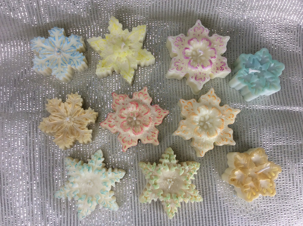 Múltiples Velas Copo Nieve Navidad de cera natural, en tonos blanco, azul, rosa y amarillo pastel.