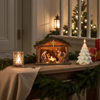 Centro de mesa navideño con la vela de árbol de Navidad con copos de nieve. al lado de un Belén