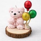 Vela artesanal de bautizo con osito rosa y globos decorativos sobre base de madera, hecha a mano con cera vegetal