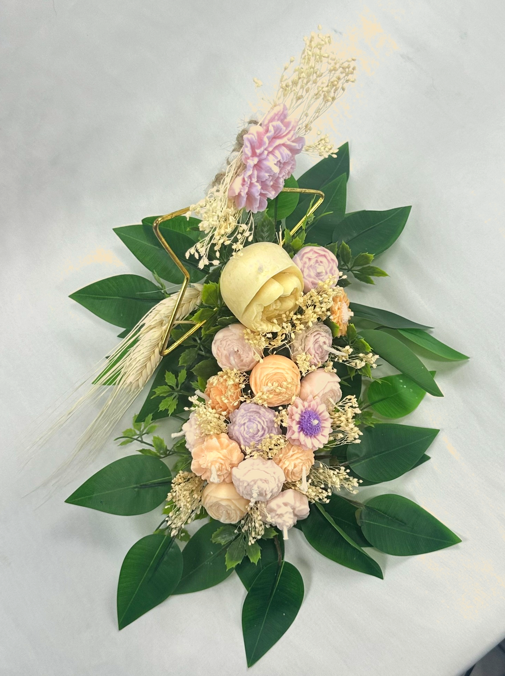 Vista superior del Centro de Velas Roma. Composición floral de arte inmortal en tonos pastel y verde. Pieza central de lujo para ceremonias religiosas.